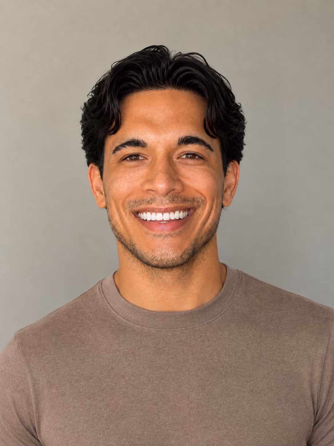 Male smiling with dark background wearing floral shirt