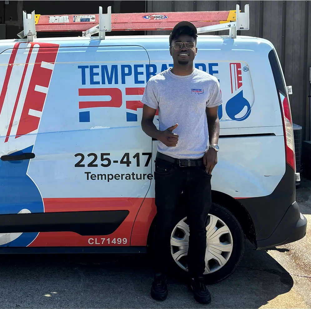 Temperature technician standing next to company van with thumbs up