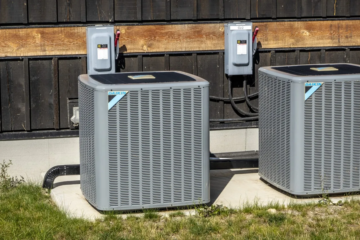 Two Daikin air conditioning units installed outside a wooden building