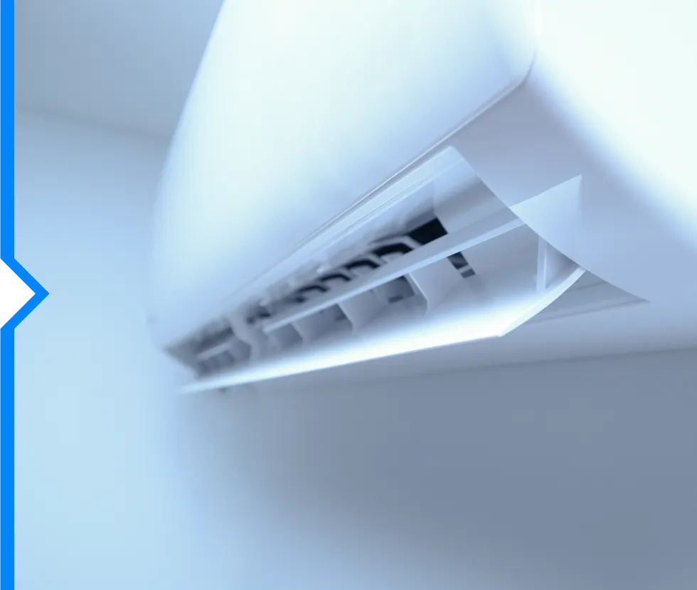 Air conditioning unit mounted on a white wall with soft lighting