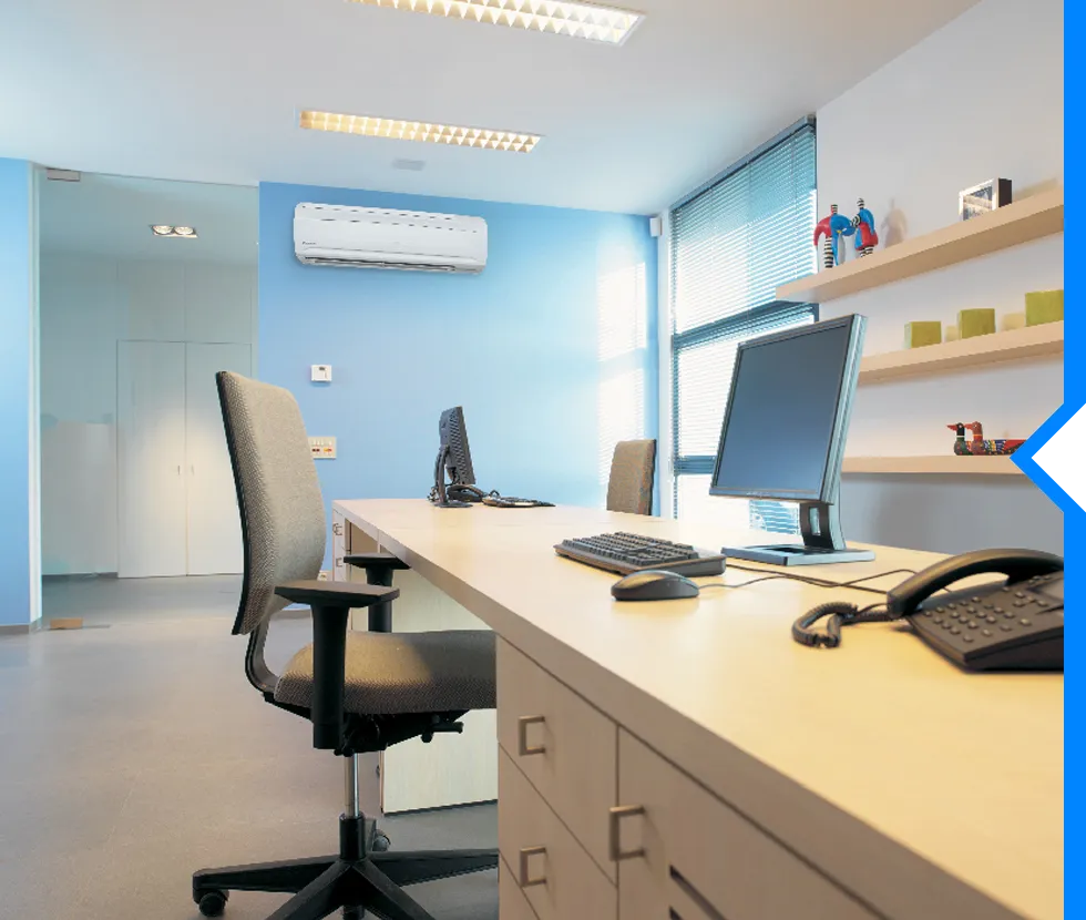 Modern office workspace with computer, desk, chair, and blue walls