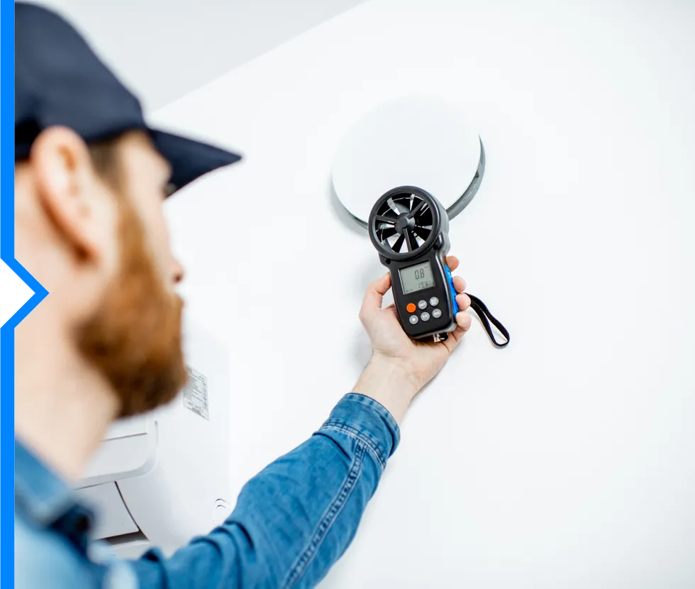 Technician using digital anemometer to measure air flow or wind speed