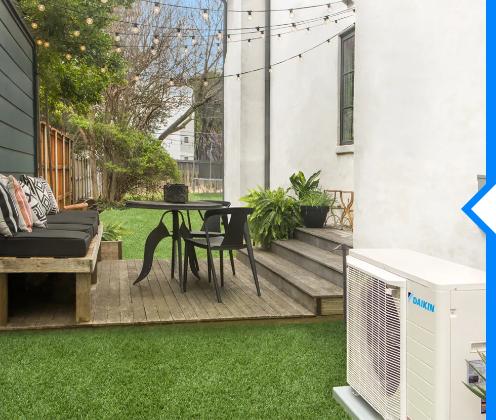 Modern backyard deck with outdoor seating, string lights, and potted plants