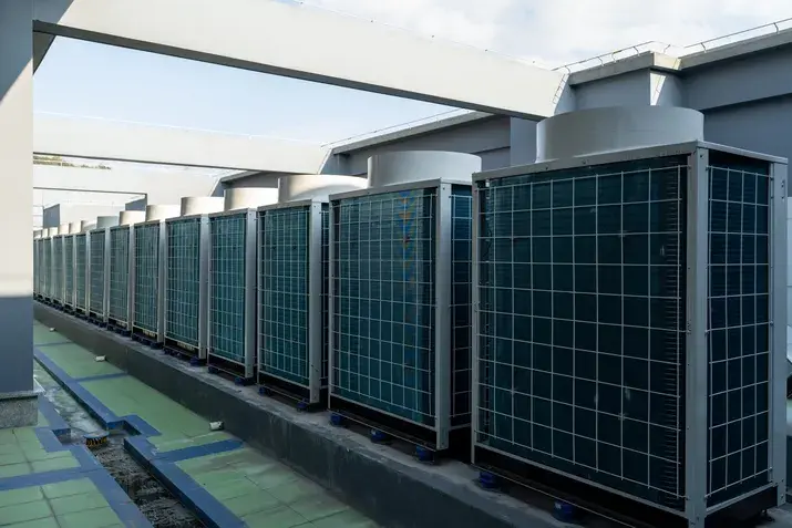 Row of green and blue solar panels on commercial building rooftop