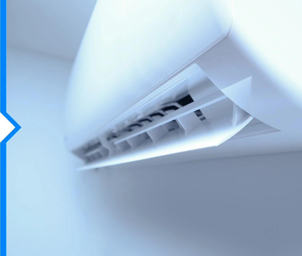 A close-up shot shows the interior components and adjustable louvers of a white, wall-mounted ductless air conditioner.