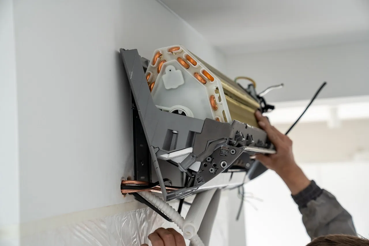 Technician installing complex air conditioning or ventilation system unit
