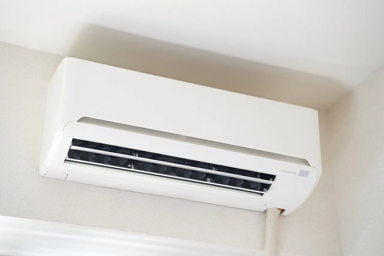 White wall-mounted air conditioning unit with black air vents