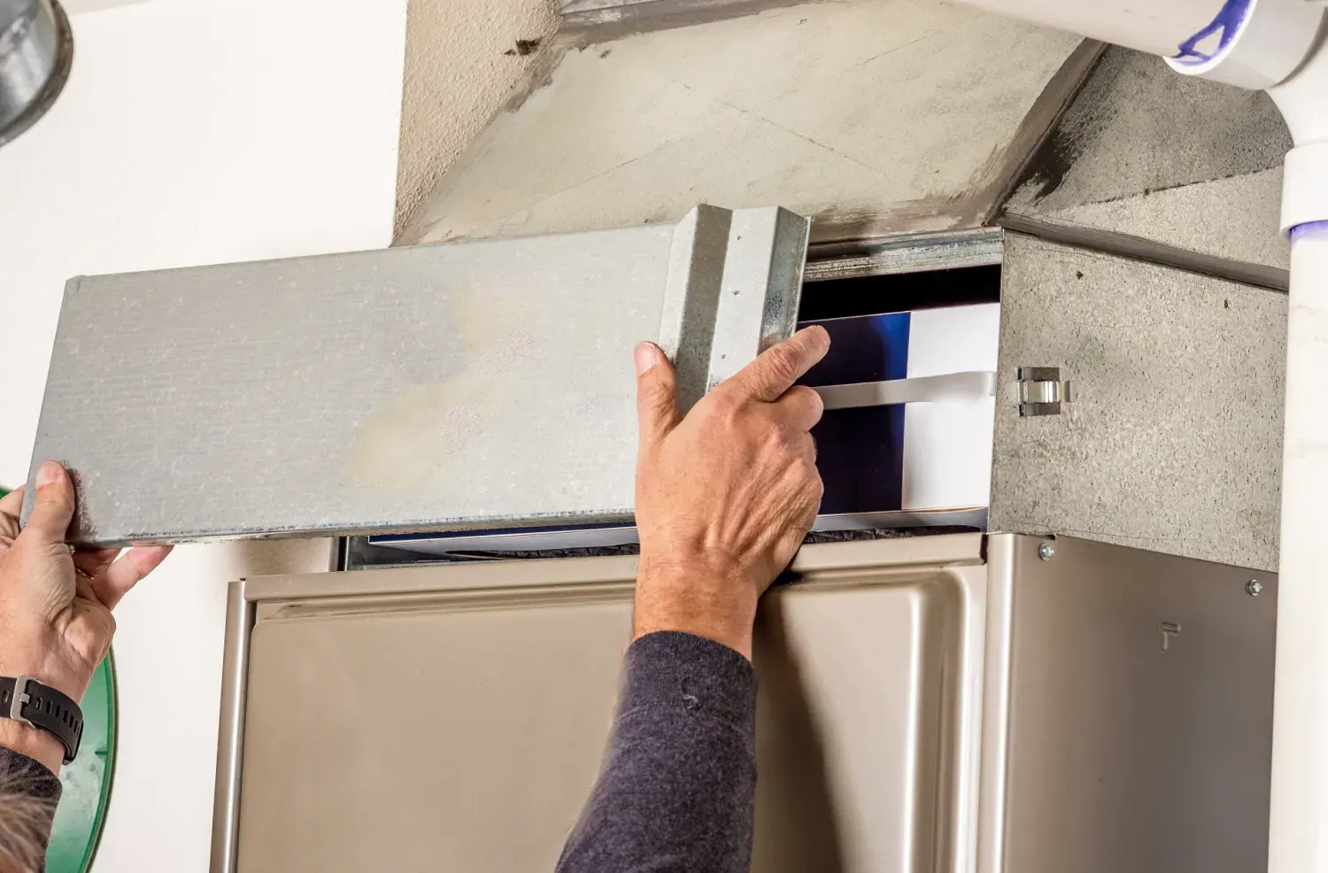 Hands adjusting metal panel on industrial equipment or appliance
