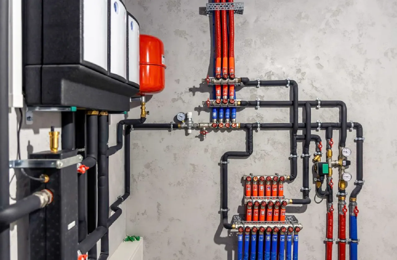 Complex heating system with red and blue pipes, valves, and expansion tank