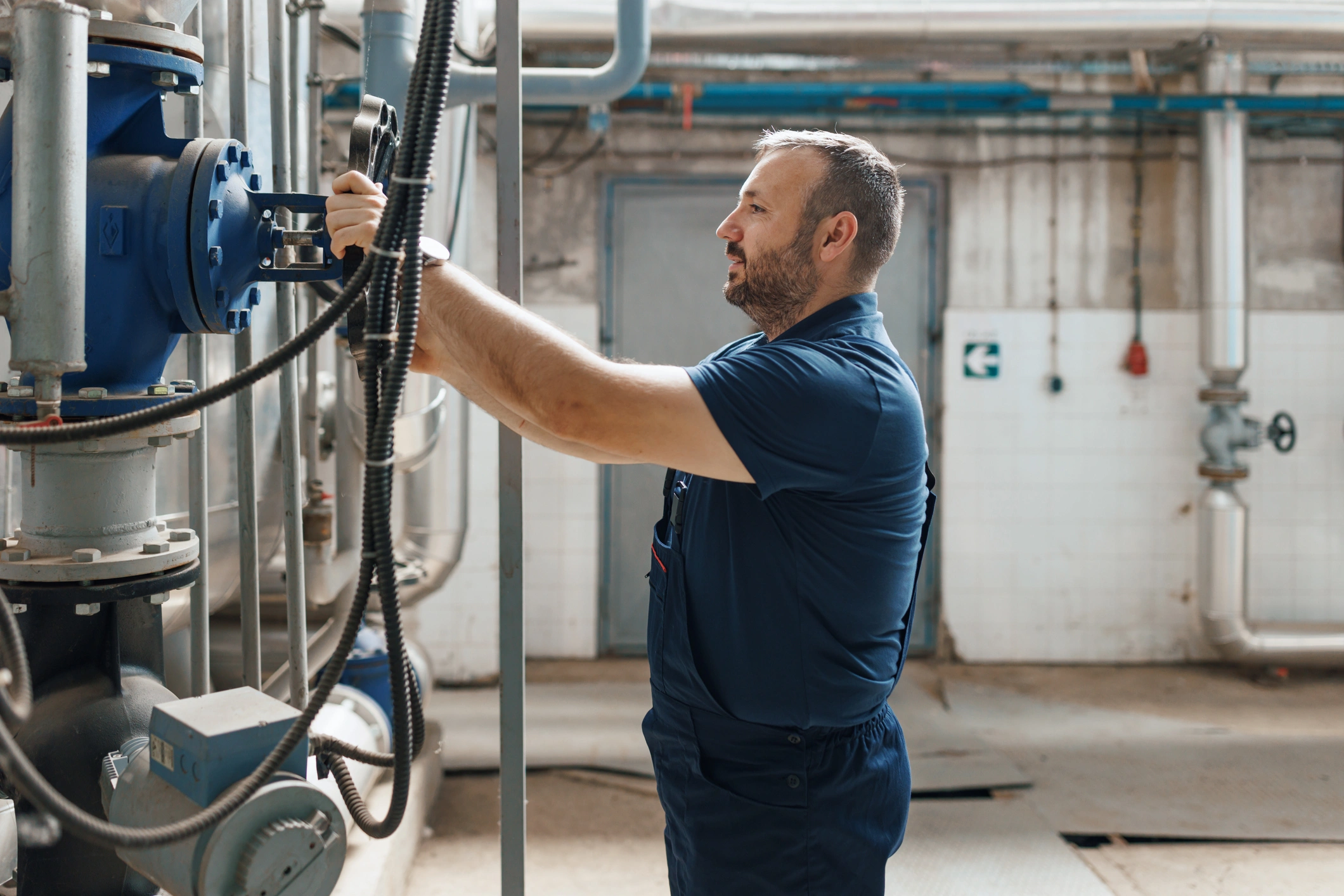 A technician in a blue shirt is servicing a water pump at Glycol Machine Service.