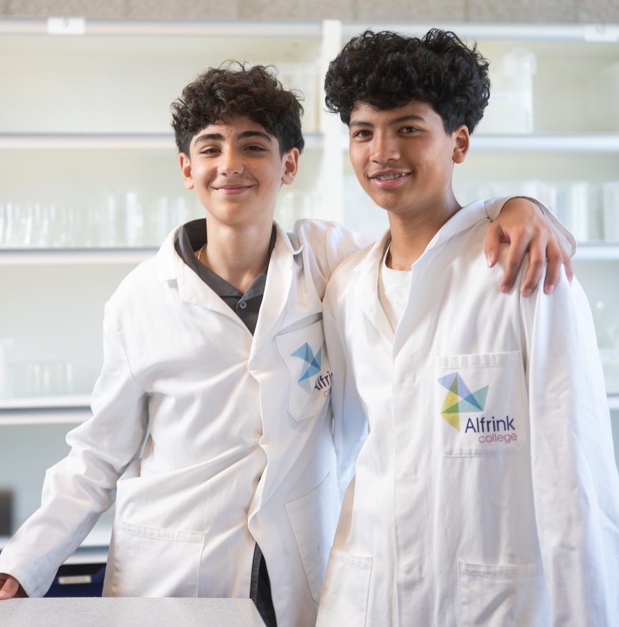 Twee leerlingen in labjassen van het Alfrink College