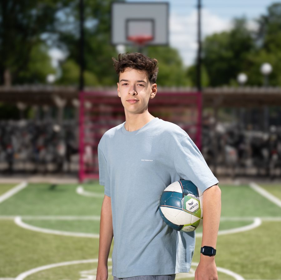 Leerling met een voetbal op het sportveld