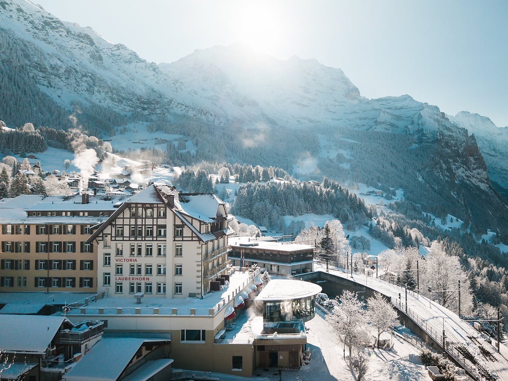 Victoria Lauberhorn in winter, with the snow-covered Bernese Alps rising behind the village