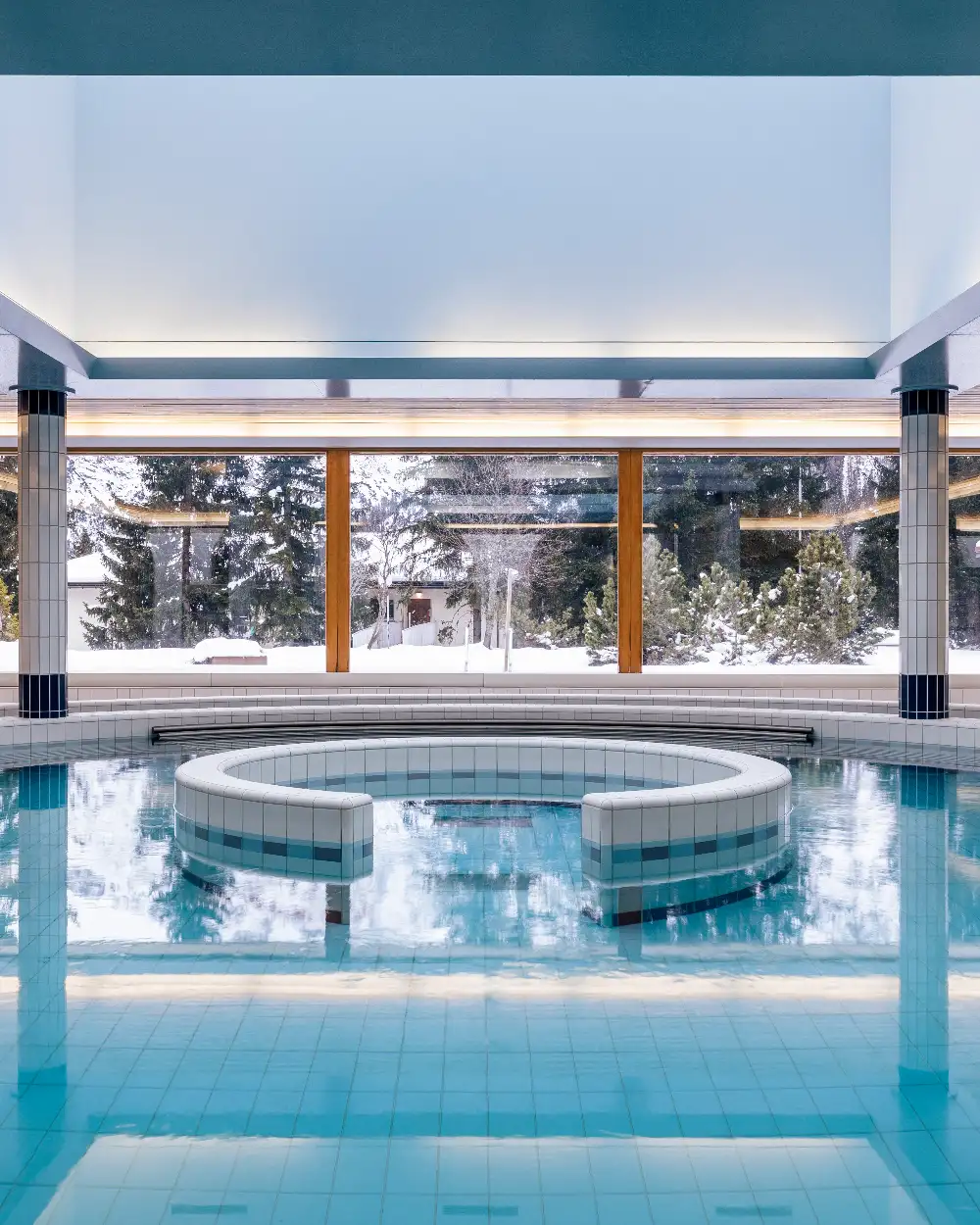 Indoor pool at Altein with a view of snow-covered pines