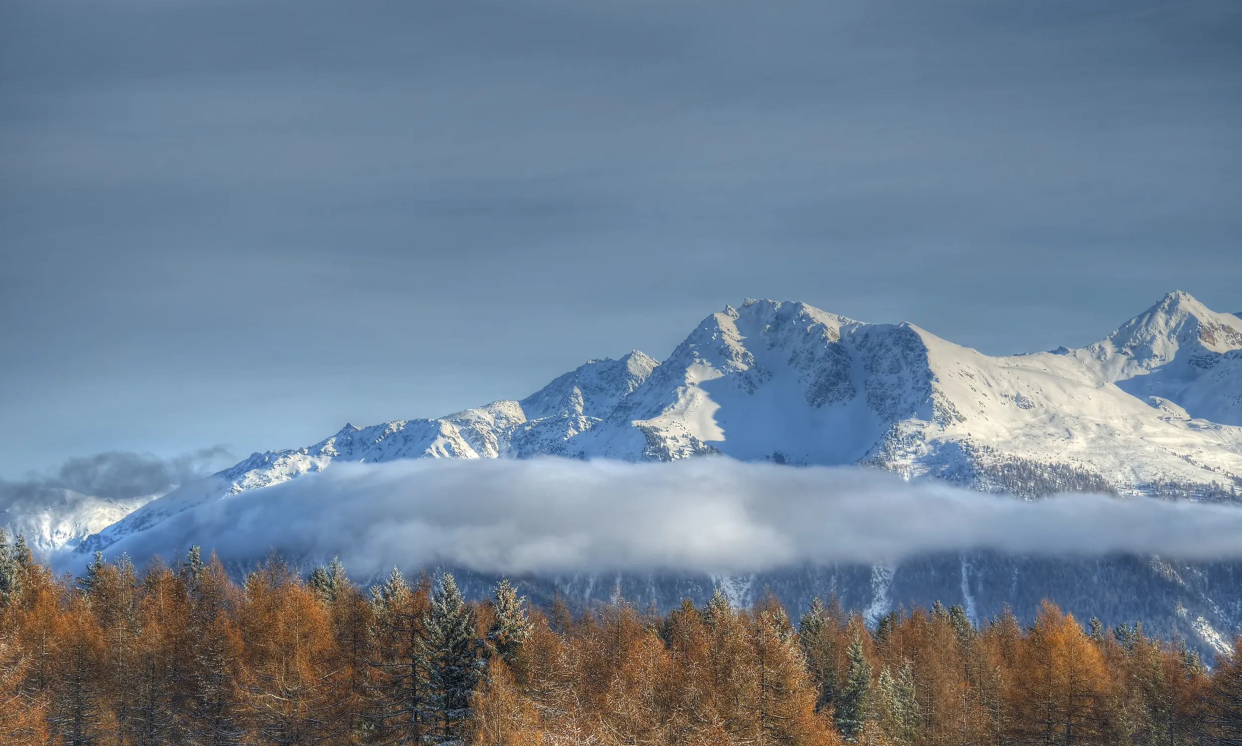 Hiker watching sunrise over mountain range.