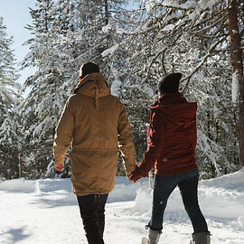 Four people paddleboarding on a misty lake at sunrise with mountains in the background.