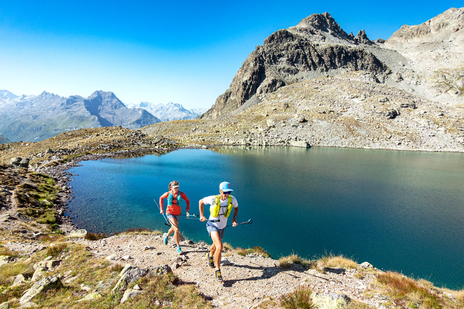 Coureurs de trail passant près du lac de montagne Lej da la Tscheppa au-dessus de Sils en Engadine