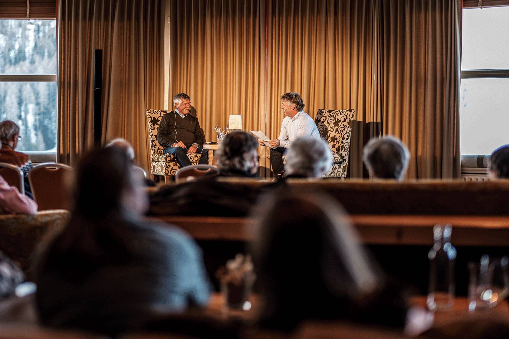 Due uomini in conversazione sul palco durante un incontro dell'estate culturale in un hotel ad Arosa