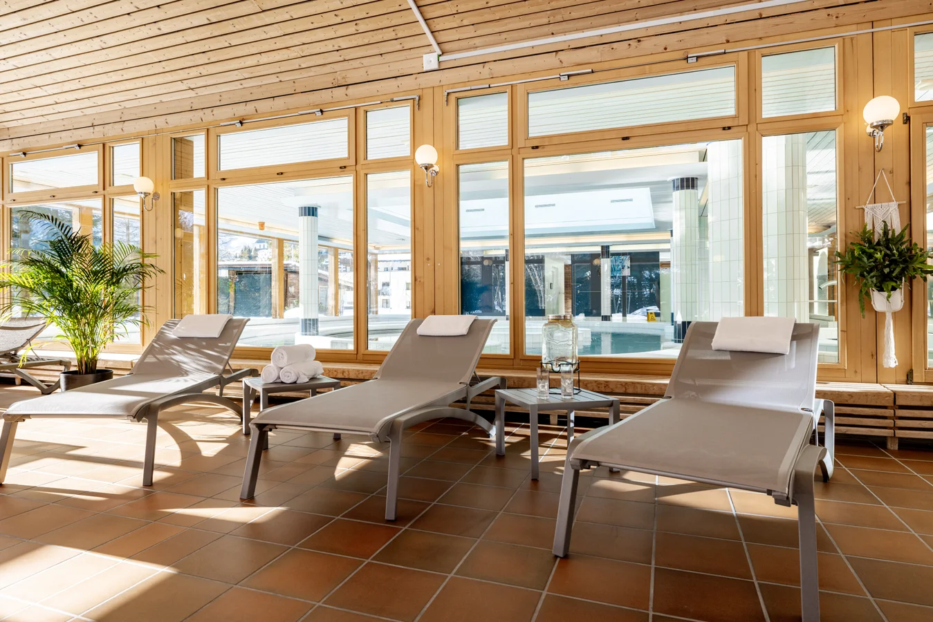 Relaxation room at the Arosa wellness area at Altein with loungers facing full height windows and wood panelled walls