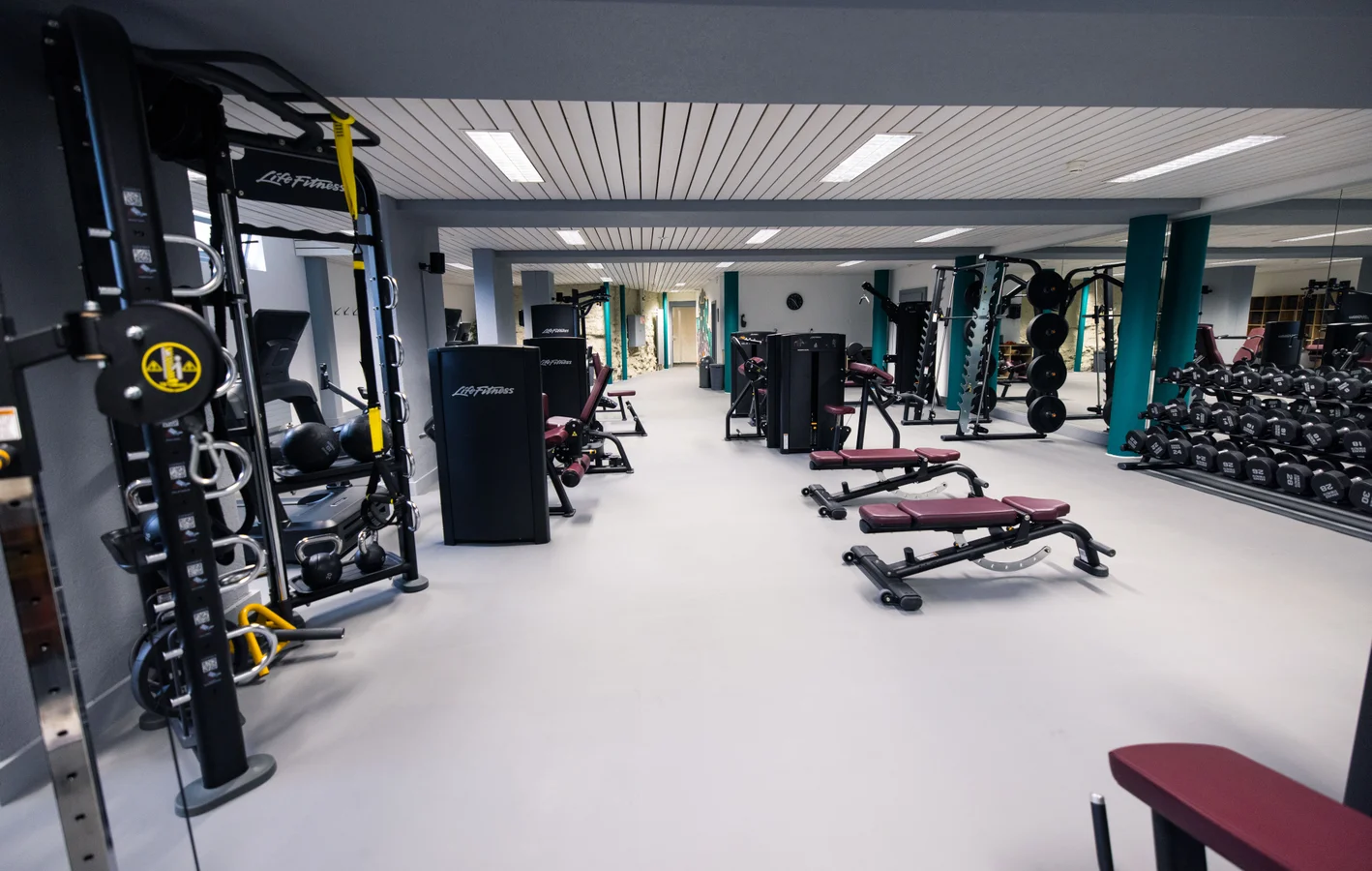 Gym in Wengen at Victoria Lauberhorn with cable stations, benches, a dumbbell rack and mirrored walls