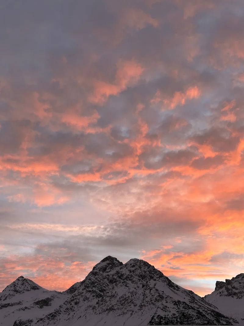 Cime innevate sopra Arosa sotto un cielo rosa e arancione
