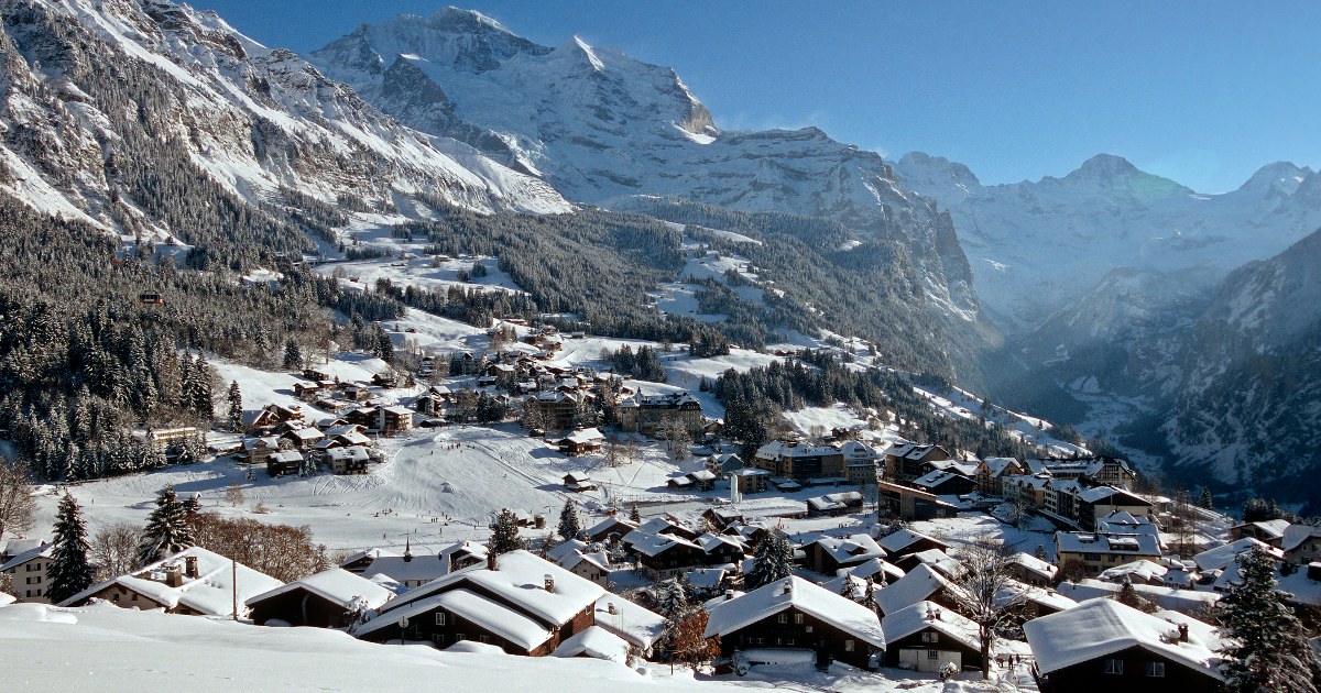 Aerial view of Wengen under snow on its terrace, with the Jungfrau behind