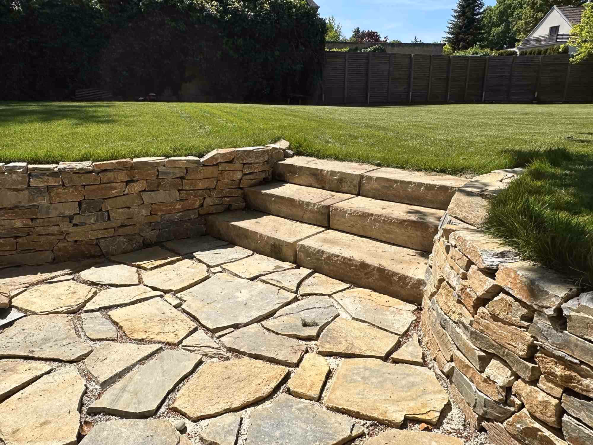 Gartengestaltung, Natursteinmauer aus Gneis und Naturstein Blockstufen.