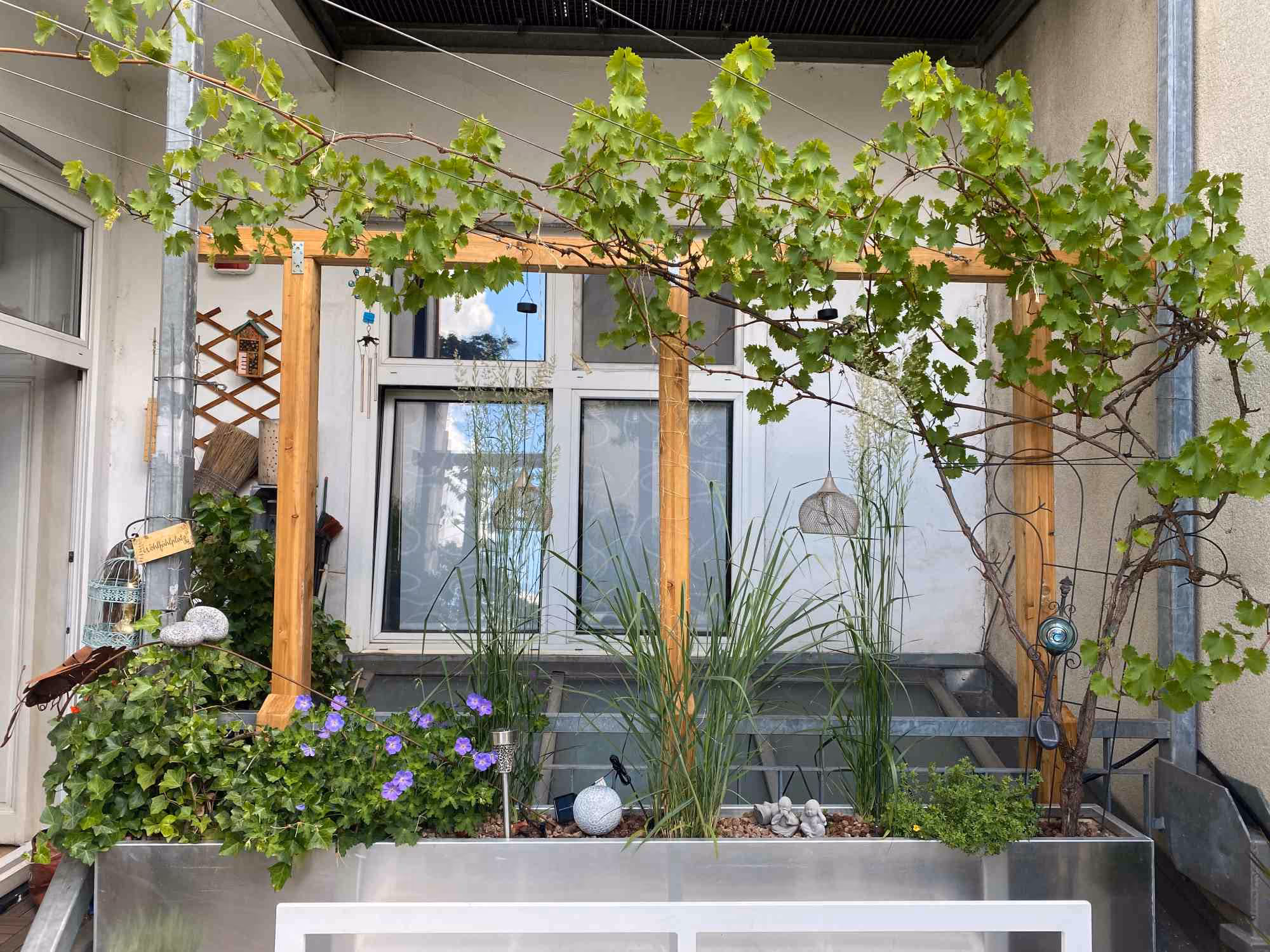 Moderne Terrasse mit Hochbeet und bepflanzter Holzverkleidung