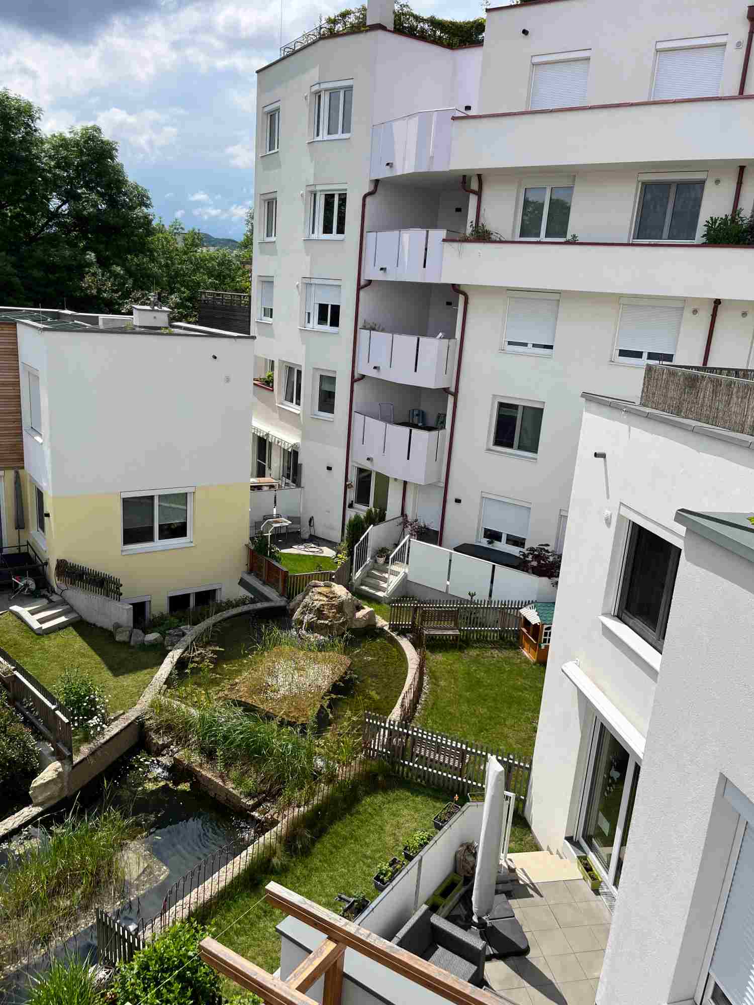 Urbaner Garten mit kleinem Biotop auf verschiedenen Ebenen.