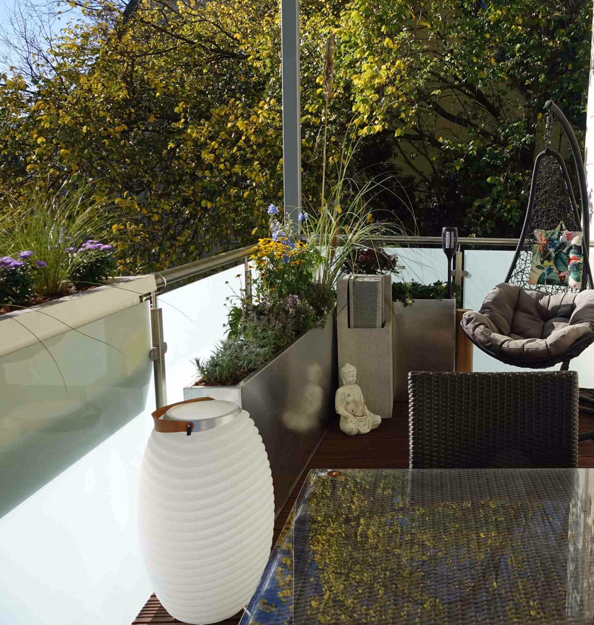 Urbaner Balkon mit Pflanzkübeln und gemütlichem Essbereich