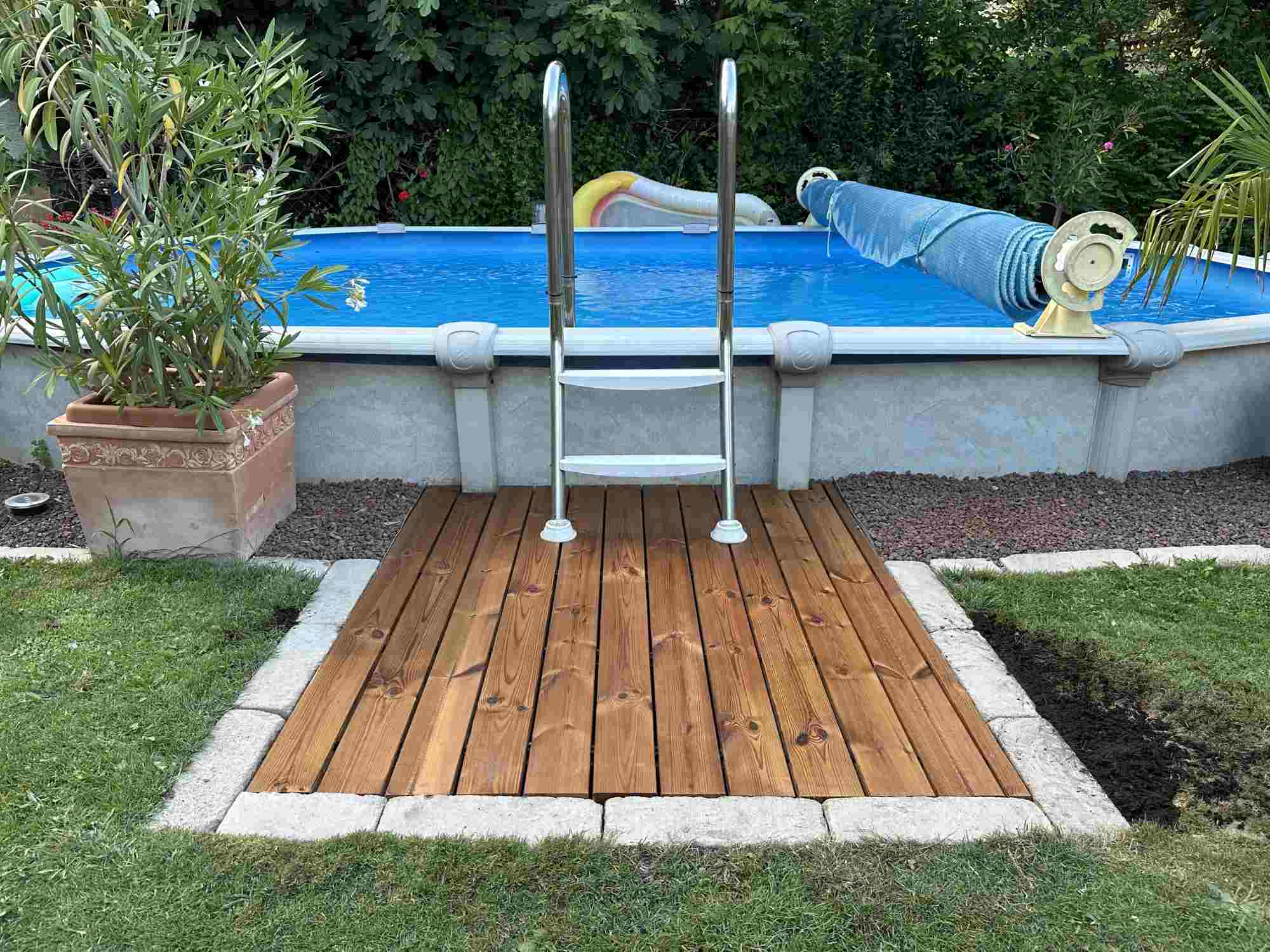 Holzplattform mit Einstieg für Poolbereich im Garten