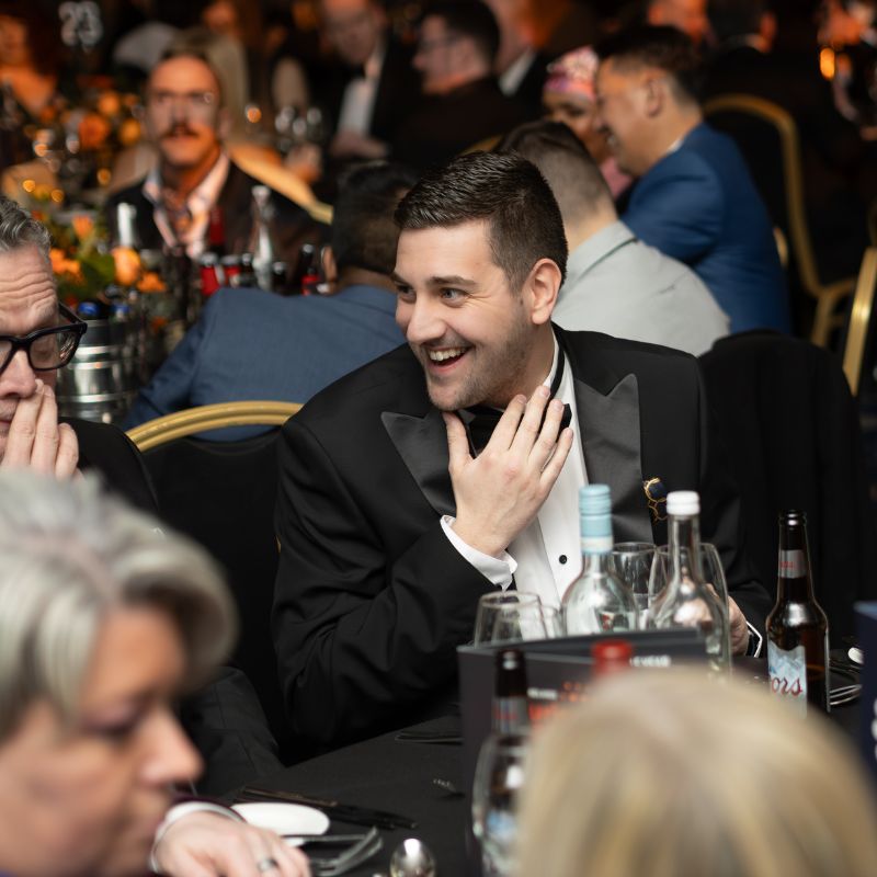 Man laughing at awards ceremony