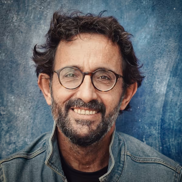 man in gray denim jacket wearing black framed eyeglasses