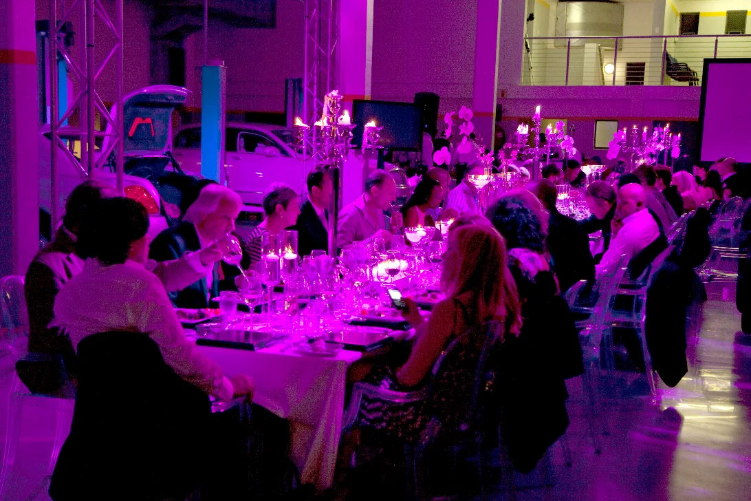 Guests at a gala dinner lit in purple