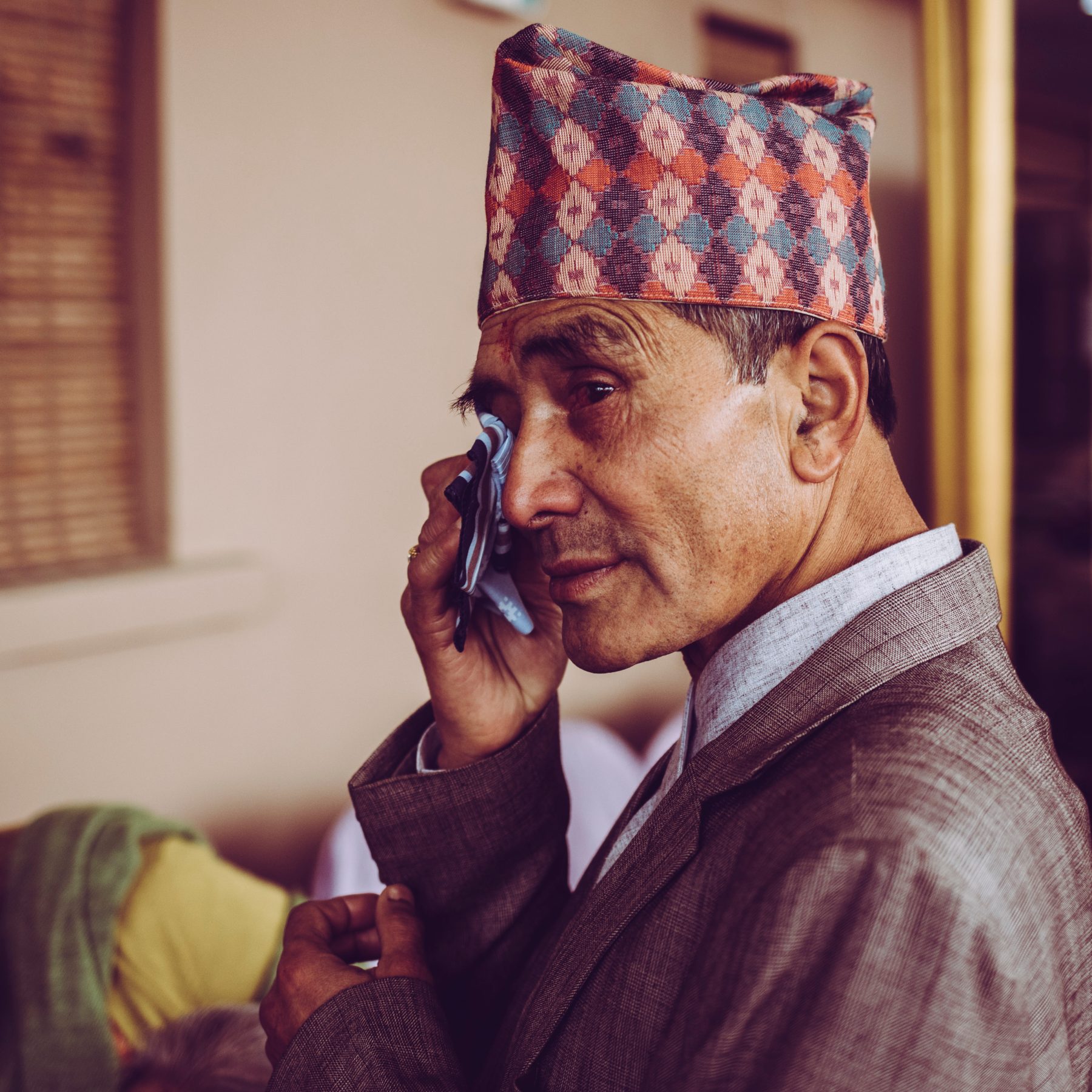 Colourful portrait of a man in a patterned hat on the phone