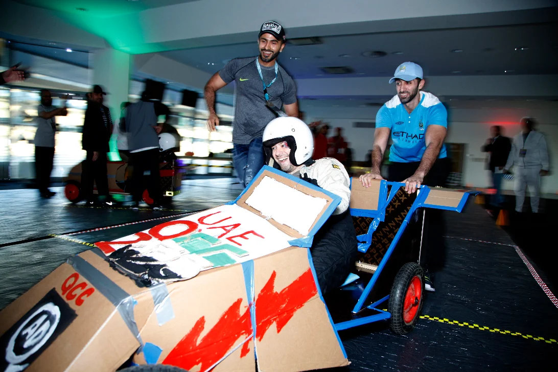 Team racing a cardboard soapbox car at a motorsport team day