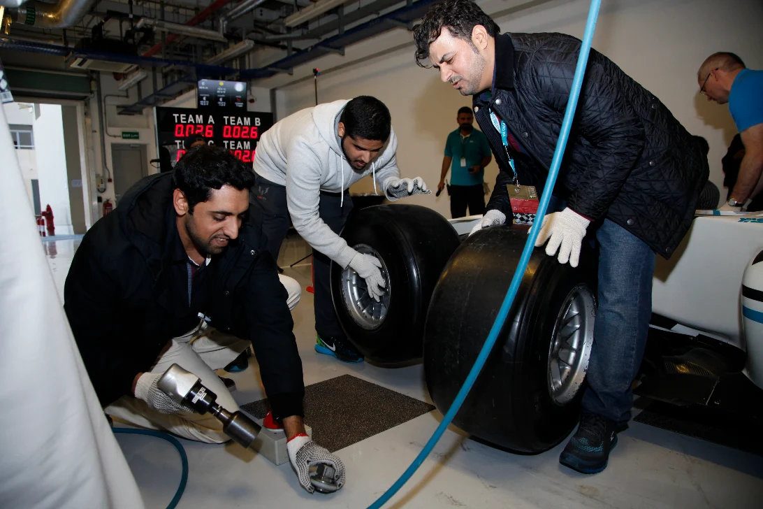 Guests changing a race car tyre in a pit-stop challenge