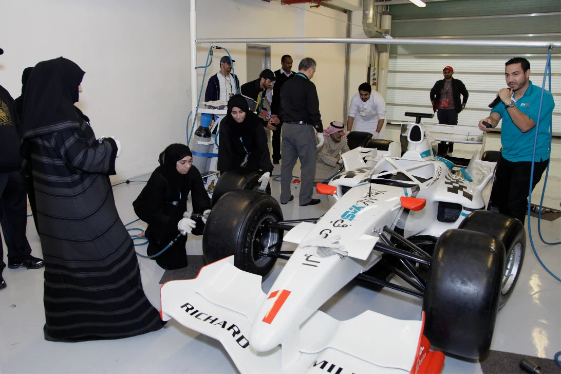 Teams working on a single-seater race car in the garage