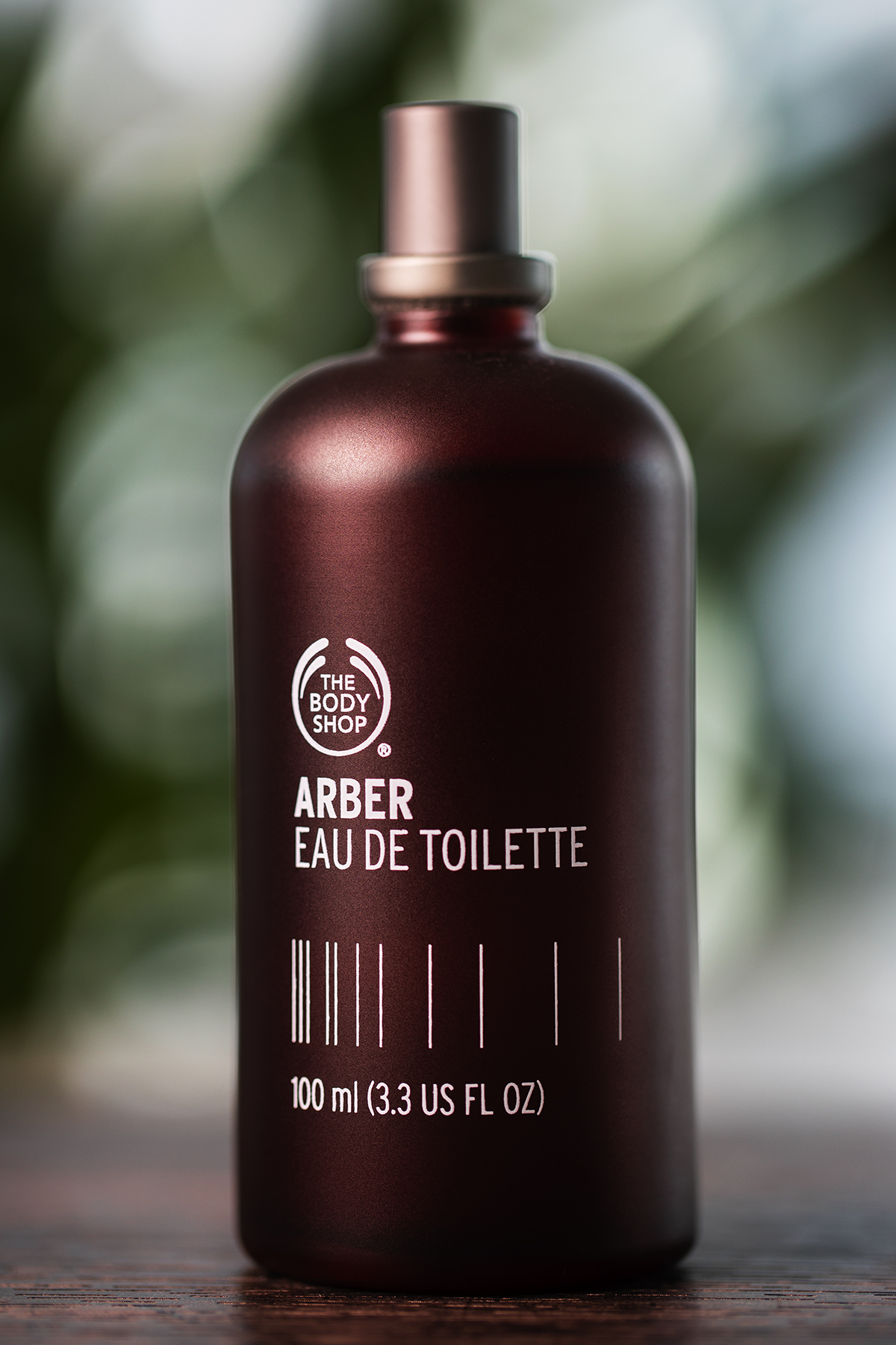 Dark glass fragrance bottle with soft green backlight