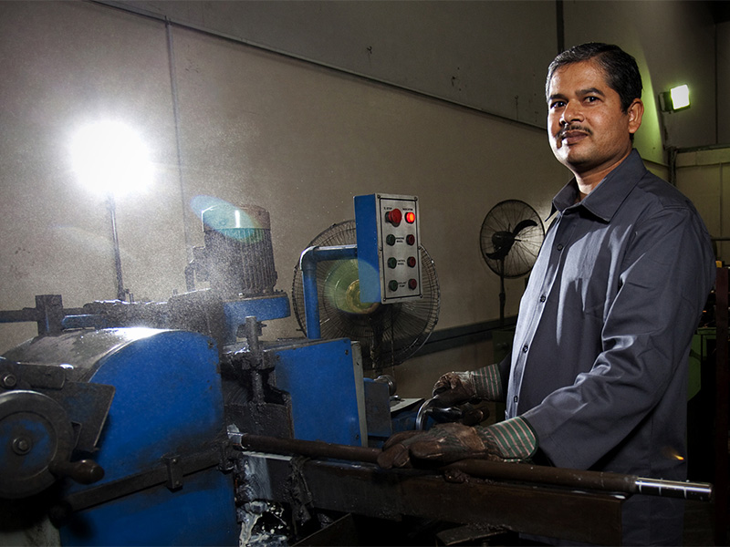 Engineer standing beside machinery in his workshop