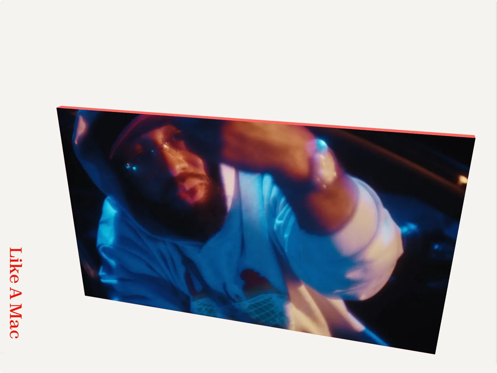 Man wearing a hoodie and cap, sitting in a dimly lit car at night with blue and red lighting.