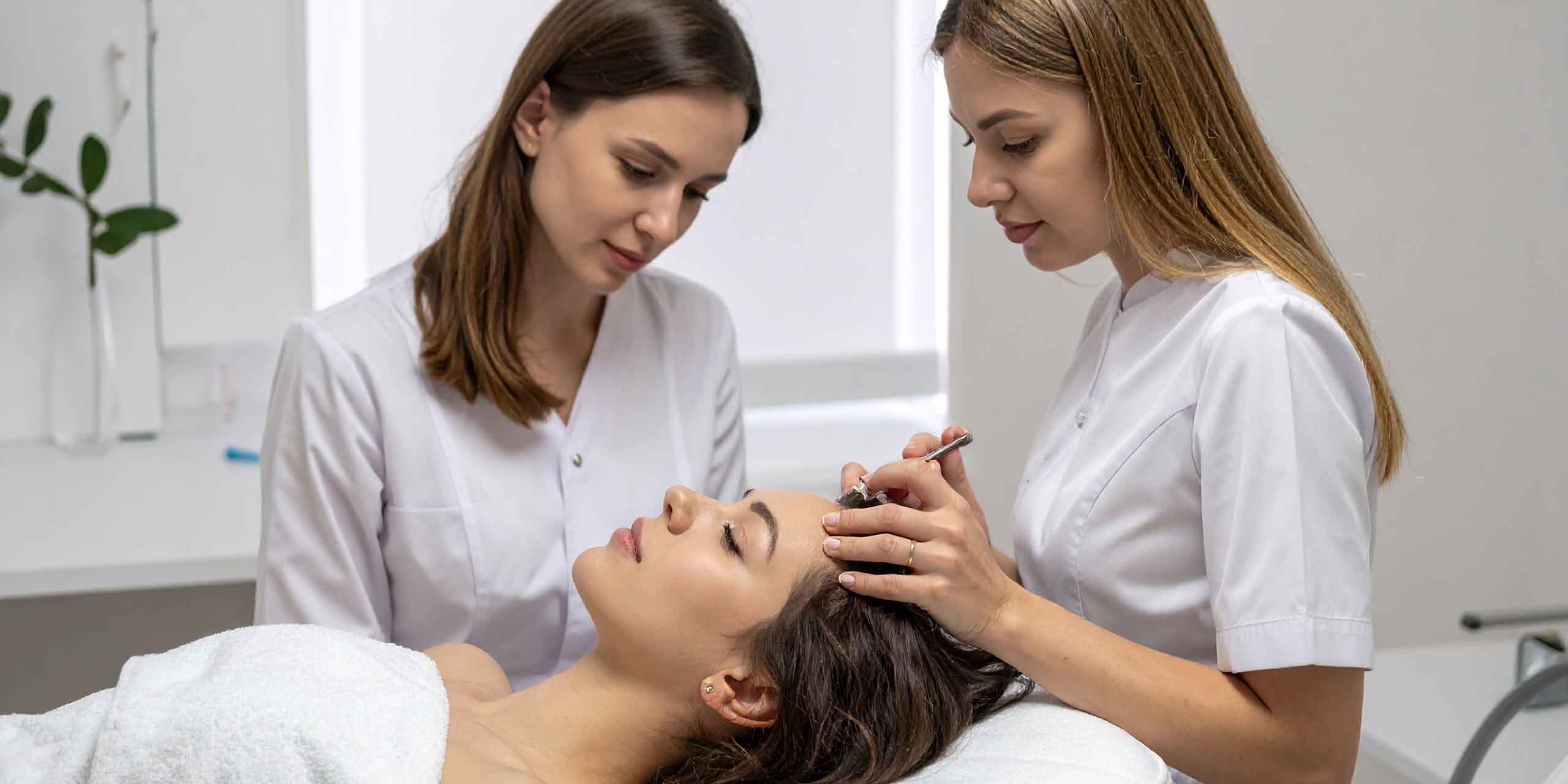 Zwei Frauen stehen bei einer Patientin