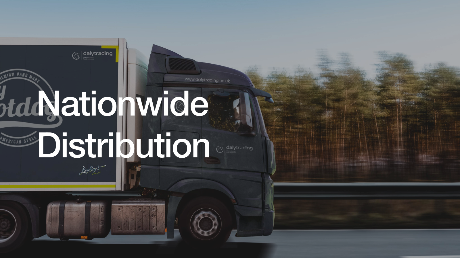 Side view of a large delivery truck driving on a highway with trees in the background and the text 'Nationwide Distribution' overlayed.