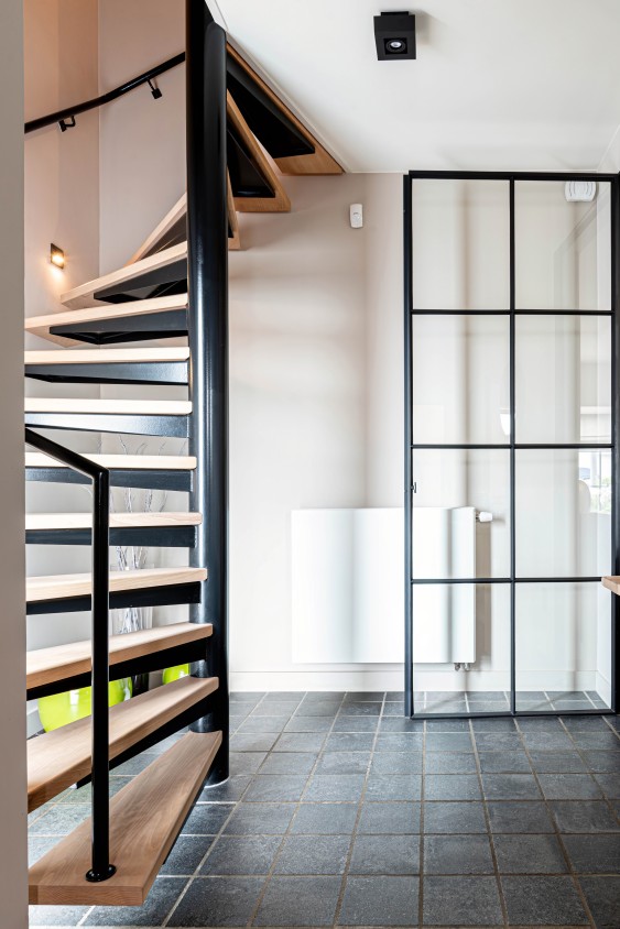 Zwarte spiltrap met houten treden en glazen wand