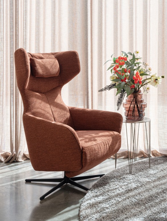Roestbruine oorfauteuil met bijzettafel en bloemen