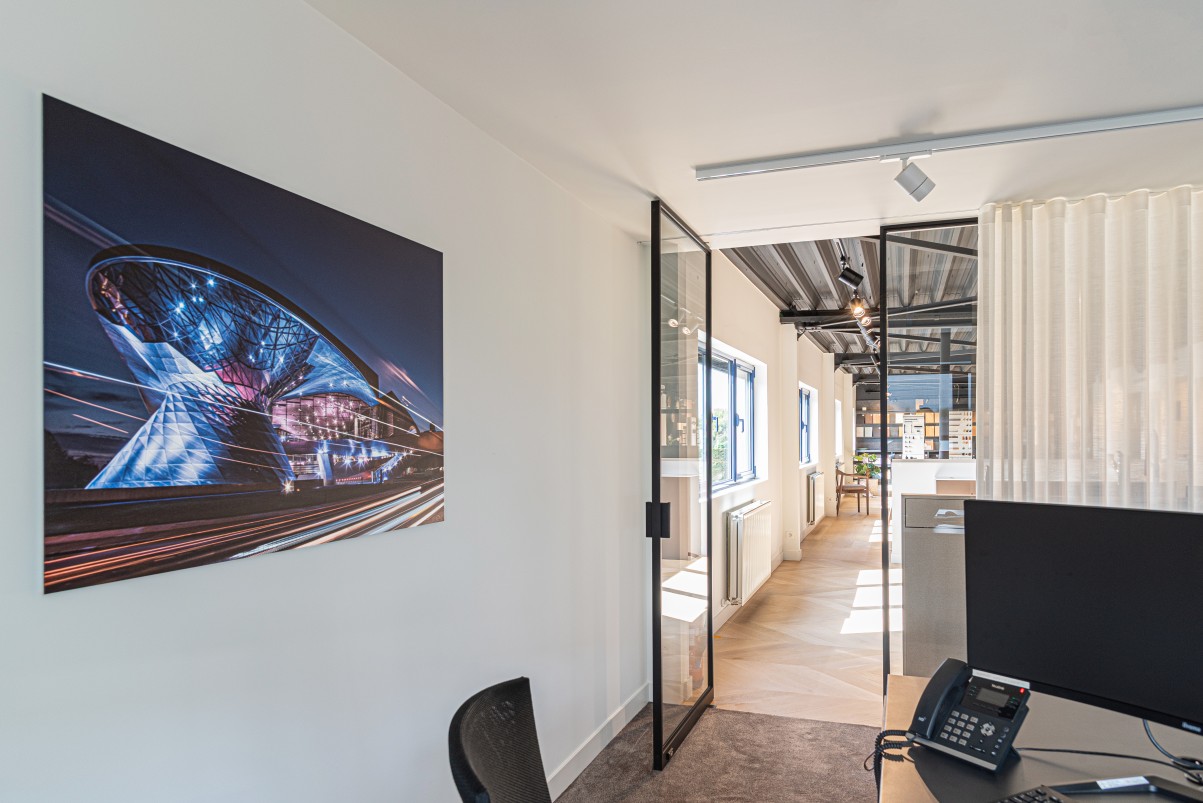 Modern kantoor met wandfoto en glazen scheidingswand