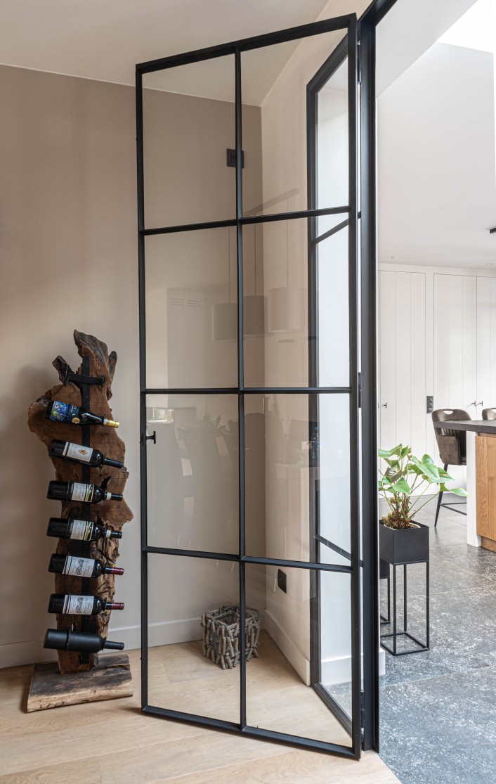 Zwarte stalen taatsdeur met glas en houten wijnrek