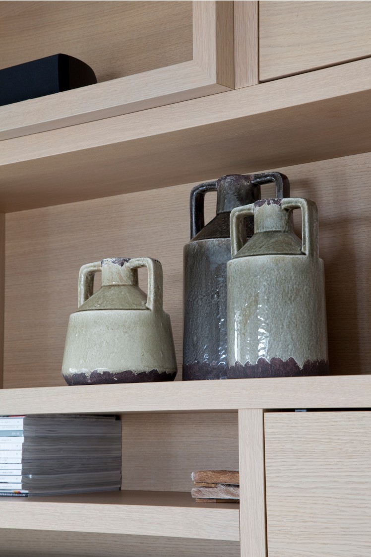 Detail van decoratieve kruiken op eikenhouten kastplank