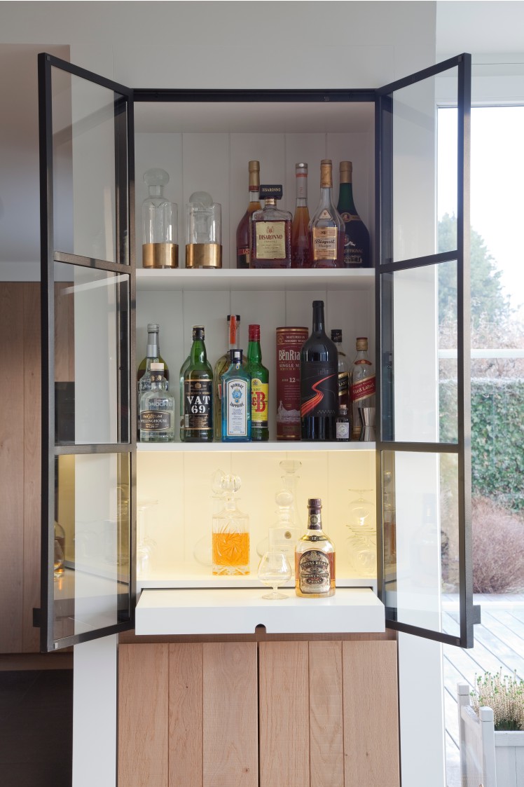 Open glazen drankkast met flessen en glaswerk