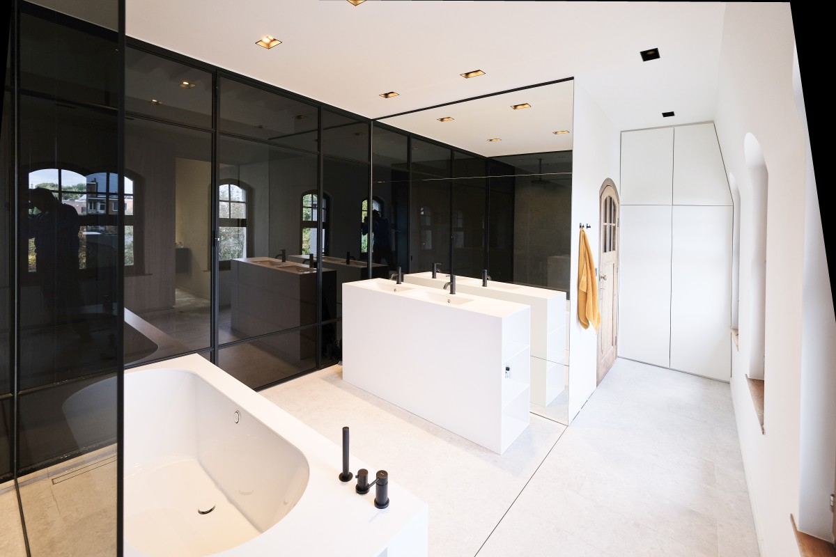 Luxe badkamer met vrijstaand bad en zwarte glaswanden